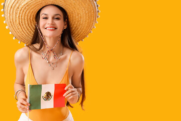 Canvas Print - Beautiful woman in sombrero hat and with Mexican flag on yellow background