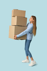 Sticker - Pretty young woman with cardboard boxes on blue background. Moving house concept