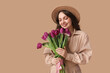 © Pixel-Shot - Happy young woman with bouquet of beautiful purple tulips on brown background
