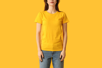 Poster - Young woman in stylish yellow t-shirt on color background