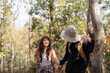 © Natee Meepian - Cheerful romantic lesbian couple traveler with backpack on their backs go hiking through the forest in the mountains in summer