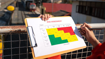 Wall Mural - action of a business manager is holding project risk assessment form on blurred background of train 