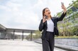 © StockPhotoRepublic - Young Asian Woman holding coffee cup and using phone outdoor in a central business district area