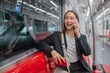 © StockPhotoRepublic - Asian businesswoman talking on phone while on the way traveling to the airport in a metro skytrain
