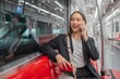 © StockPhotoRepublic - Asian businesswoman talking on phone while on the way traveling to the airport in a metro skytrain