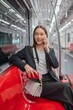 © StockPhotoRepublic - Asian businesswoman talking on phone while on the way traveling to the airport in a metro skytrain