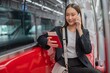© StockPhotoRepublic - Asian businesswoman talking on phone while on the way traveling to the airport in a metro skytrain