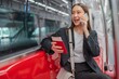 © StockPhotoRepublic - Asian businesswoman talking on phone while on the way traveling to the airport in a metro skytrain