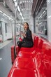 © StockPhotoRepublic - Asian businesswoman with luggage using phone while taking a public skytrain transport to the airport