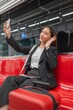 © StockPhotoRepublic - Young Asian Businesswoman Using Phone On The Public Skytrain