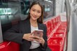 © StockPhotoRepublic - Young Asian Businesswoman Using Phone On The Public Skytrain