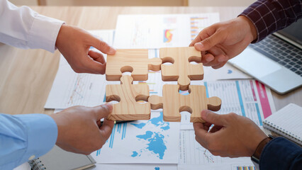 Concept of teamwork, cooperation and partnership. Business people connecting puzzle pieces in office. teamwork, Unity, volunteer, success and strategy.  Business idea by merging jigsaw puzzle.