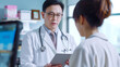 © Graphic Master - Confident Chinese doctor using a digital tablet to explain test results to a patient