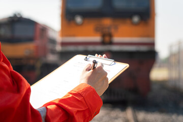 Wall Mural - a service technician is checking on heavy machine maintenance checklist, with an ancient train locom