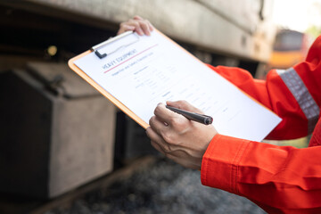 Wall Mural - action of a mechanic engineer is checking on heavy machine checklist form to verify the quality of m