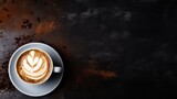 Glass filled with latte and delicately sprinkled with cinnamon rests against a black background.
