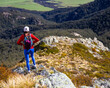 hiker girl walking down the steep trail from the top of mount somers in canterbury, new zealand south island