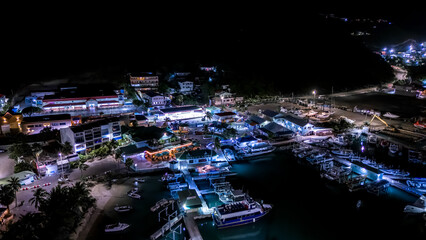 Wall Mural - Beautiful scenic aerial night view of the Caribbean island of St Maarten. Boats and yacht docked at night.