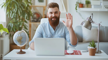 Sticker - man with a beard smiling and waving at the camera, possibly during a video call, in a bright indoor setting with modern decor.