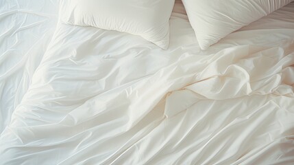 Wall Mural - Top view of a crumpled white bed with a sheet, blanket, pillows in the light and shade from the window early in the morning.