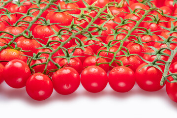 Wall Mural - Lot of red cherry tomato branches covered with small water drops isolated on white background.