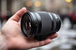© Professional Art - Camera lens in the hand of a man on a blurred background.