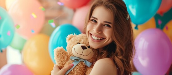 Wall Mural - Happy young woman with teddy bear at colorful birthday party