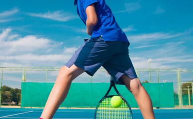 Tennis player playing tennis on a hard court on a bright sunny day