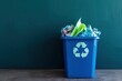 Blue recycle bin with crumpled paper on dark blue background. Reuse concept. Zero waste lifestyle. Taking care of the environment. Sorting garbage for recycling. Copy space