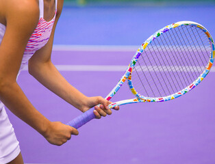 Wall Mural - close-up of the hands of a tennis player holding a tennis racket on a tennis court on a summer day