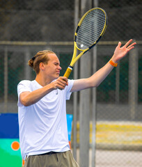 Wall Mural - Tennis player playing tennis on a hard court on a bright sunny day