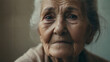 an old woman with wrinkles and a white hair looks at the camera