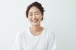© Surachetsh - Young Asian woman in serene smile, wearing white relax pajamas against a plain white background. Generative AI.