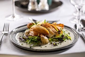 Wall Mural - Lightly smoked trout fillet, baked potatoes, beurre blanc sauce, leek and lime dressing. Creatively served fish on a plate in restaurant