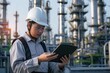 © Milkghost - Asian engineer in hard hat and safety vest using tablet at oil refinery
