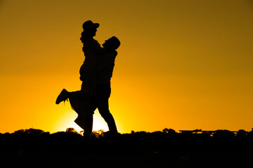 silhouettes Man and woman against the backdrop of sunset, lovers, intimacy