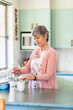 © Austockphoto - Middle aged woman in her kitchen making a cup of tea