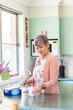 © Austockphoto - Middle aged woman in her kitchen making a cup of tea