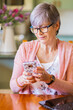 © Austockphoto - Older female person texting with mobile phone