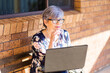 © Austockphoto - woman working on laptop outside thinking