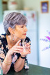 © Austockphoto - Portrait of a healthy senior woman leaning on the kitchen bench drinking a glass of water