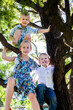 © Austockphoto - Three siblings sitting in tree together smiling