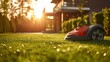 A robotic lawn mower stands on the lawn near the house at sunset