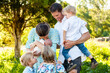 © Austockphoto - Mother and father with four children all looking at newborn sister