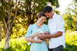 © Austockphoto - Parents holding newborn child together month old baby