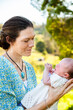 © Austockphoto - Mother looking at her newborn daughter smiling outside