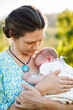 © Austockphoto - Mother snuggling her new daughter outside in sunlight
