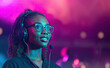 © J S - Black young female event manager or party planner woman wearing headset earphones with microphone, live concert party show in background with pink and green retro spotlights and copy space
