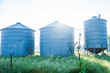 © Austockphoto - Three grain silos on farm in morning light