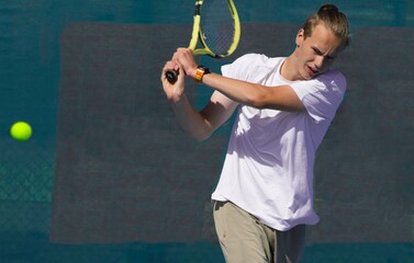 Wall Mural - Tennis player playing tennis on a hard court on a bright sunny day	